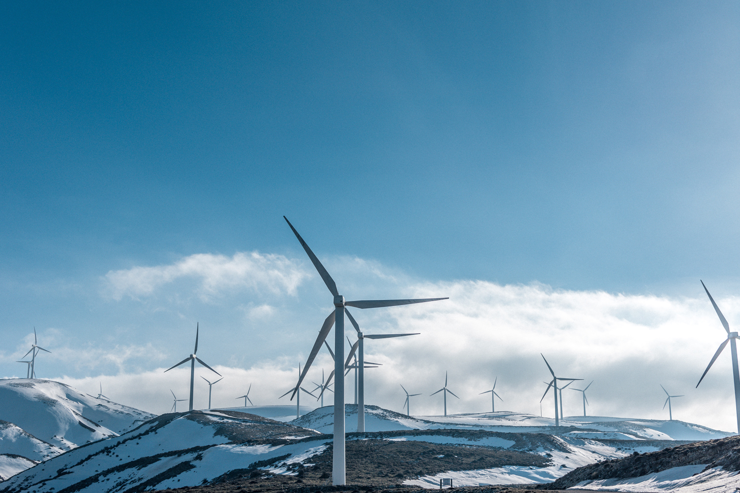 Picture of windmills in snow covered mountains.
